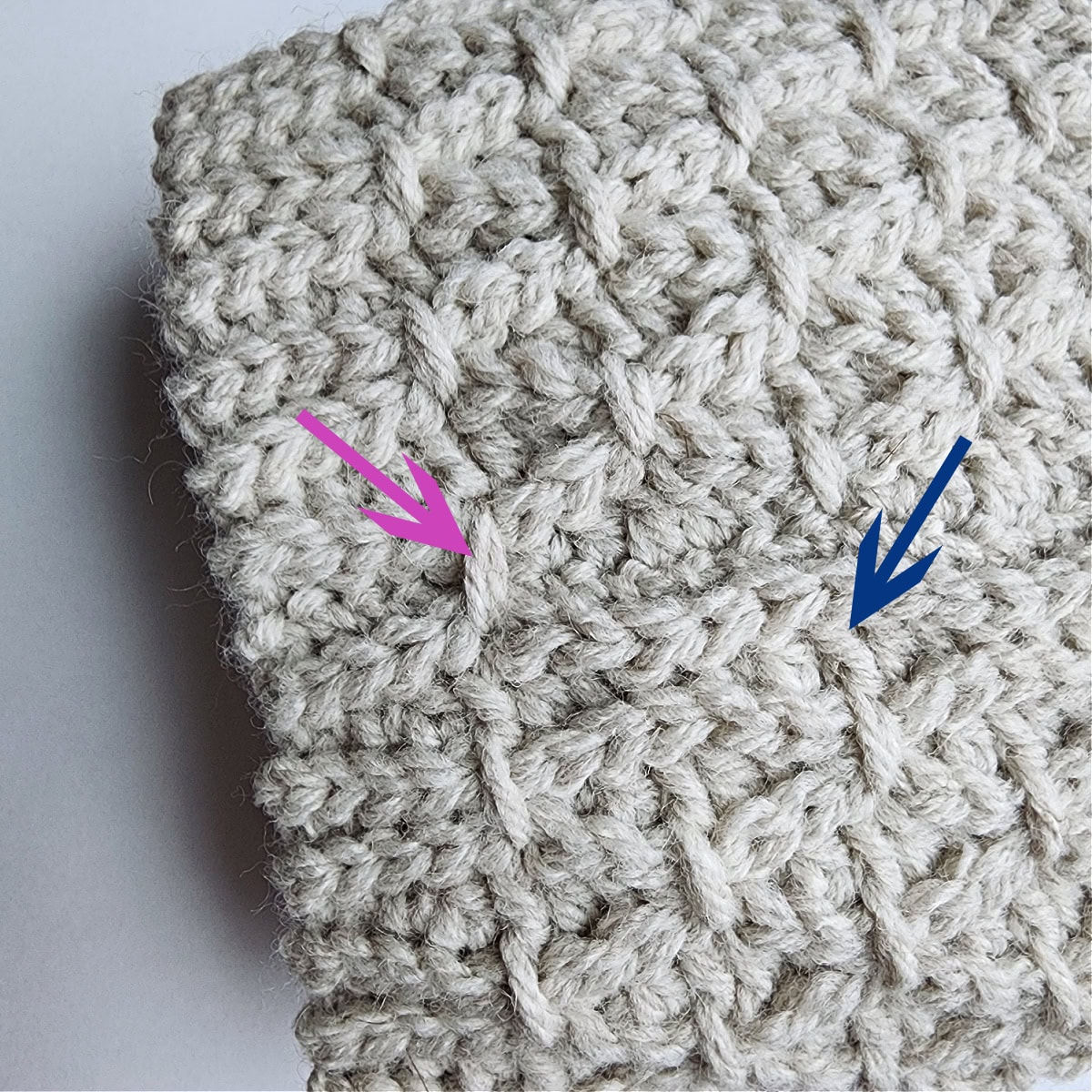 A pink arrow showing one completed finishing stitch and a blue arrow showing where to work the second finishing stitch.