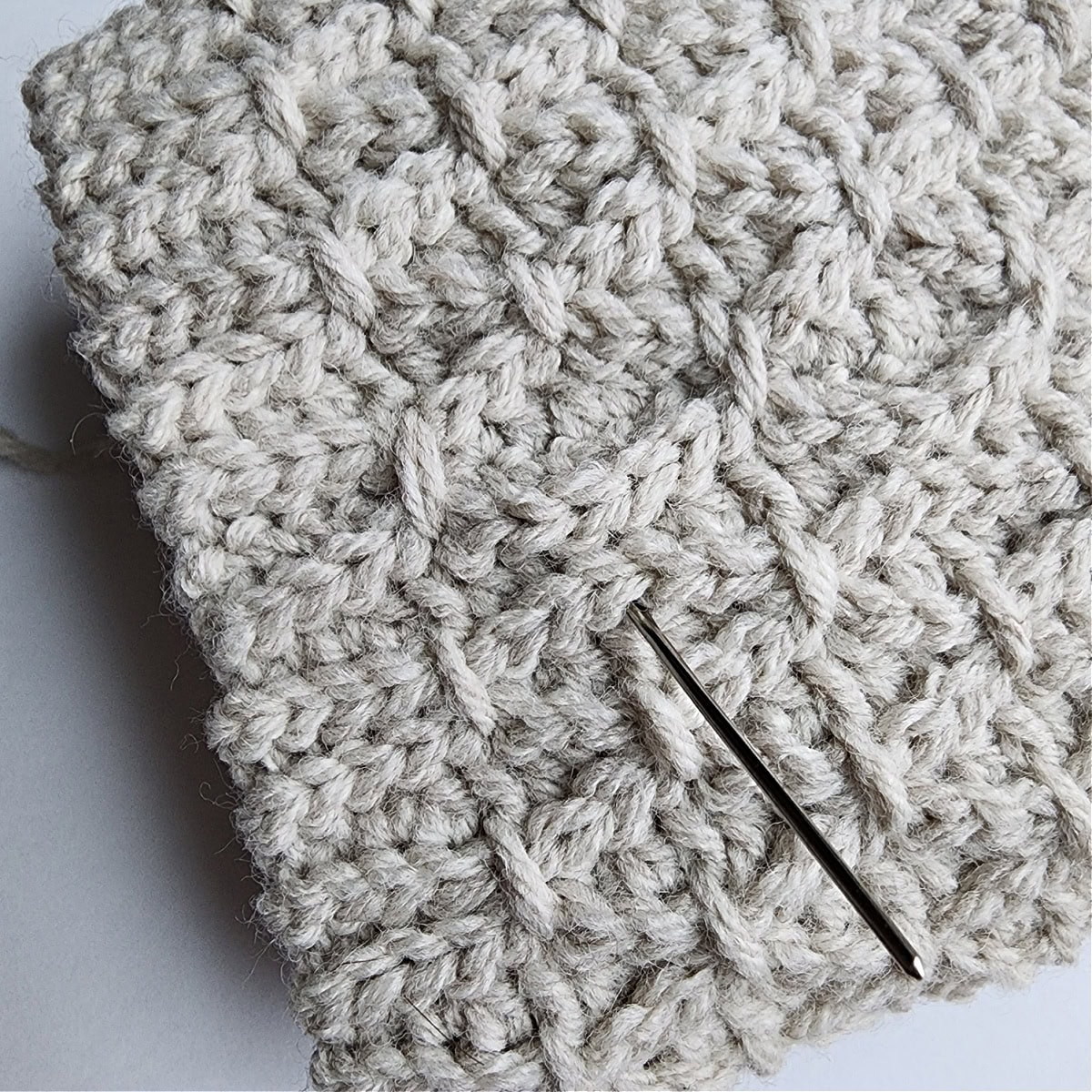 A yarn needle showing where to begin the second set of finishing stitches.