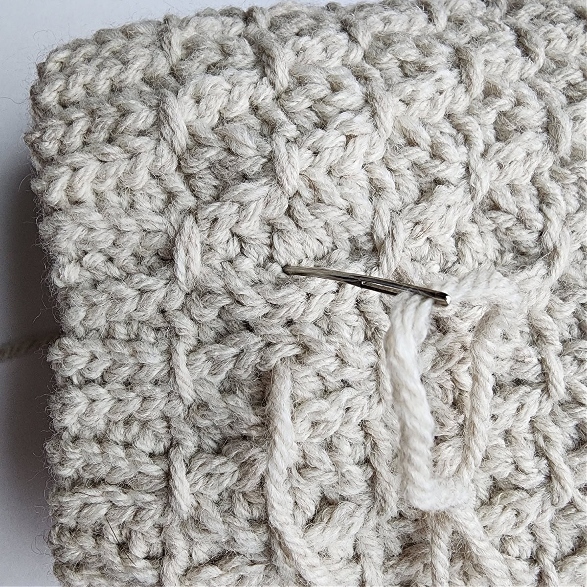 A photo showing where to insert your needle to complete the first part of the finishing stitch.