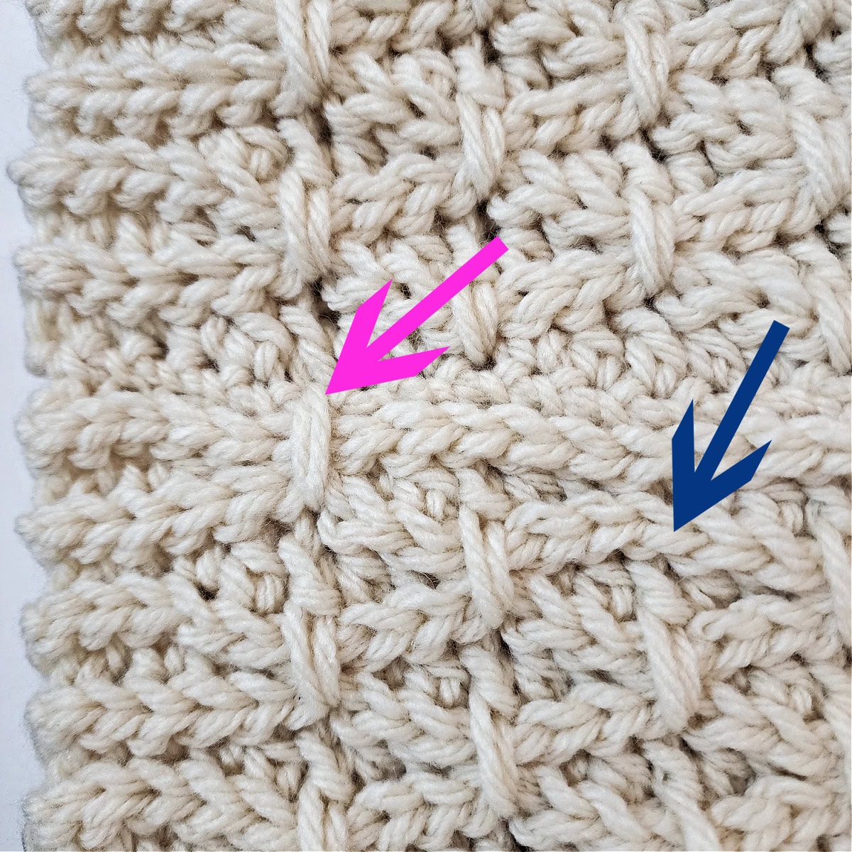 A pink and blue arrow pointing to a completed finishing stitch on a crochet cowl and where to work the next one.