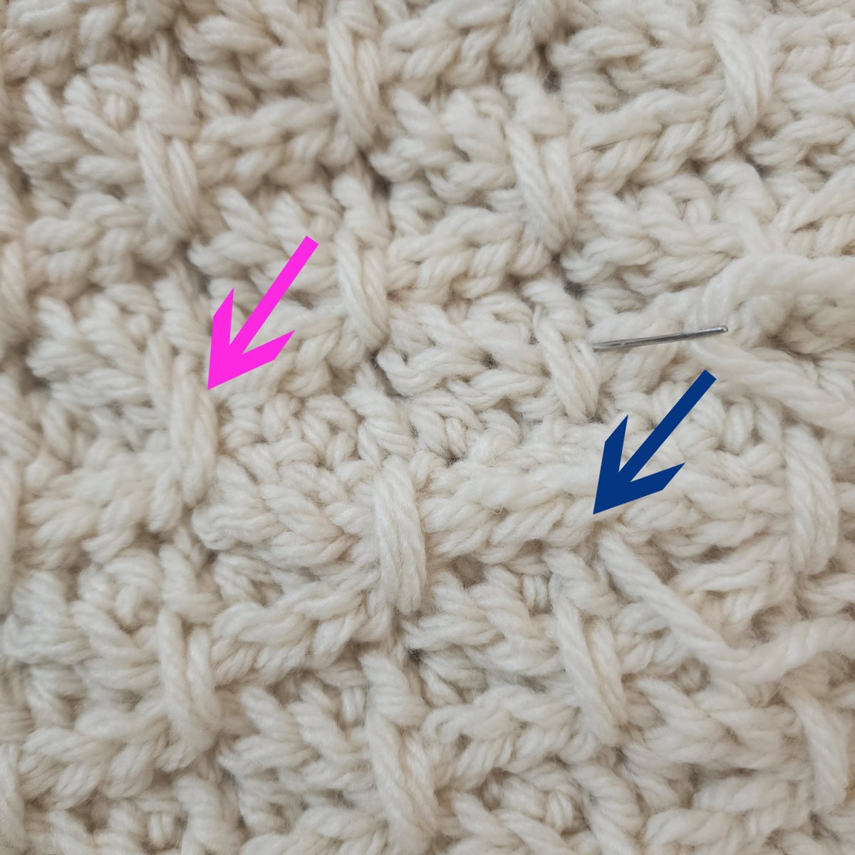 A pink arrow pointing at one finishing stitch on the crochet cowl pattern and a blue arrow pointing to the next crochet stitch where you will work another finishing stitch.