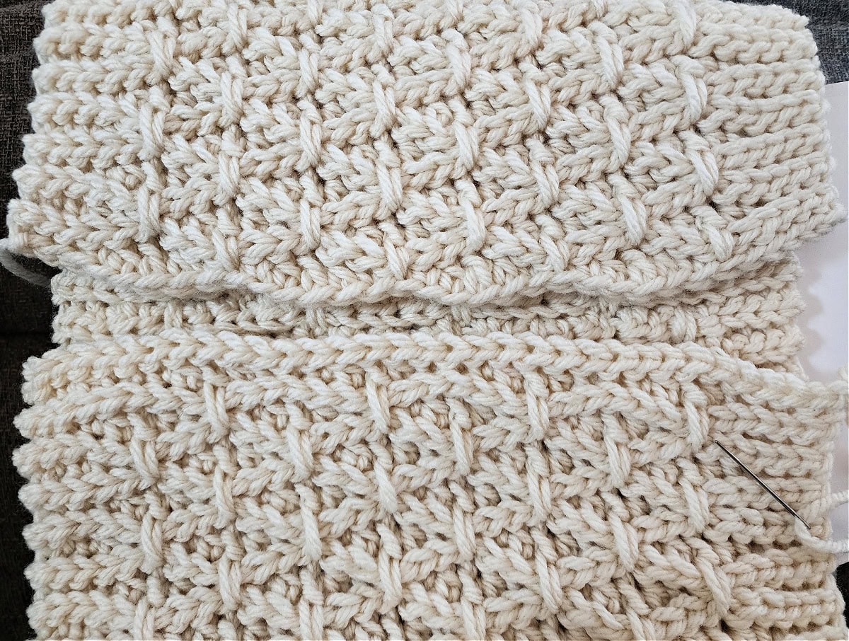 A crochet cowl that was made sideways is ready to have the edges whipstitched together.