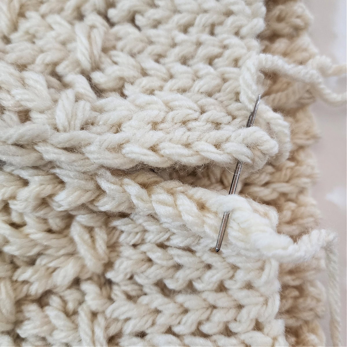 Yarn needle showing which loops ot whipstitch together to seam the crochet cowl.