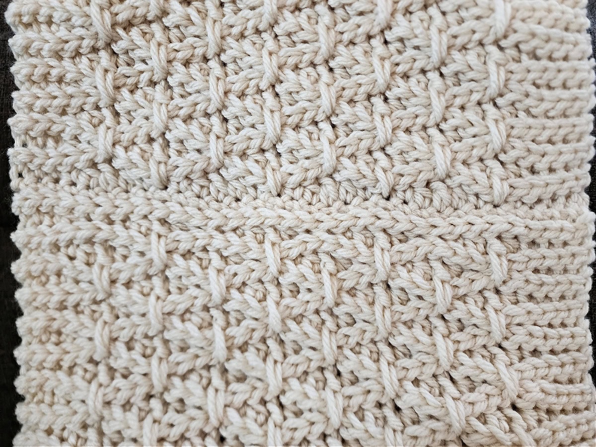 A free crochet cowl pattern in cream chunky yarn that has been seamed.