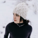 Woman modeling a crochet hat pattern made with chunky weight yarn.