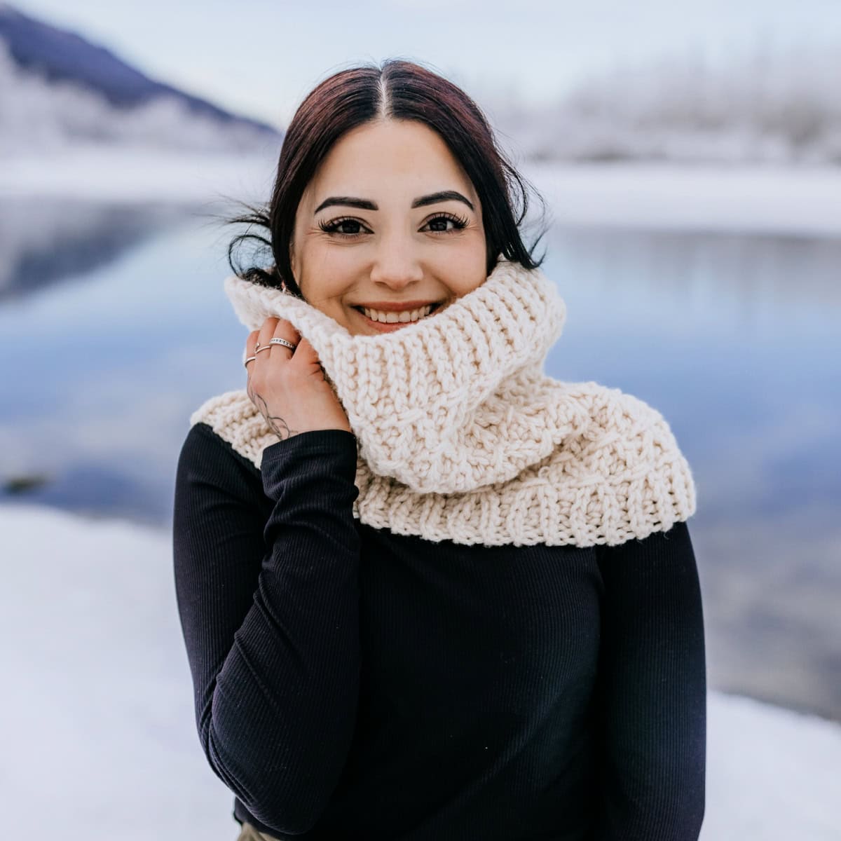 Model wearing a cream color free crochet cowl pattern with knit look stitch pattern in chunky yarn.