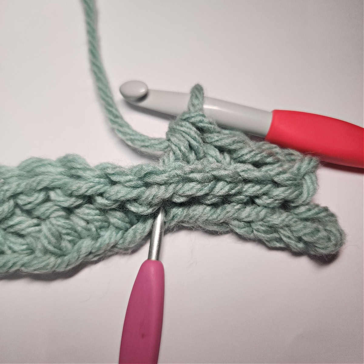 A tutorial photo showing where to work a double crochet a couple rows down.