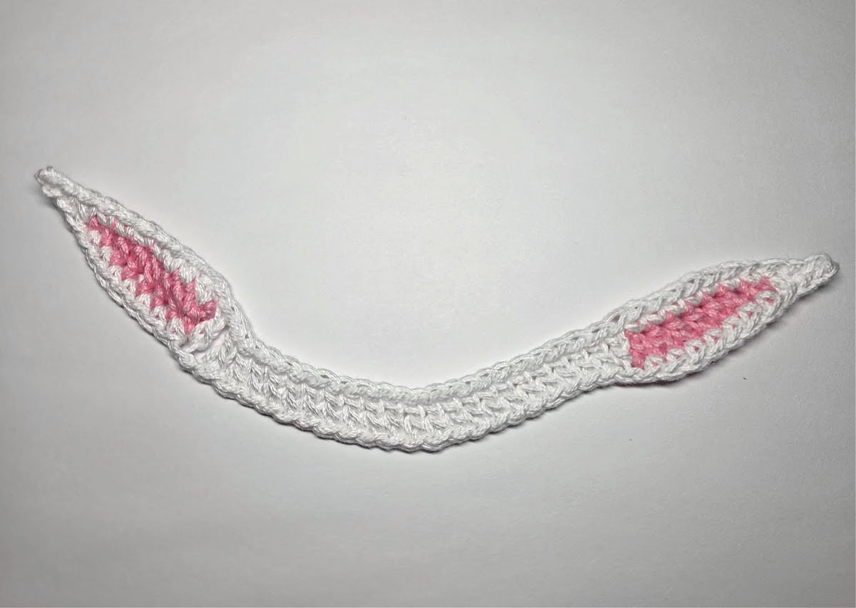 Crochet bunny ears napkin rings laid flat.