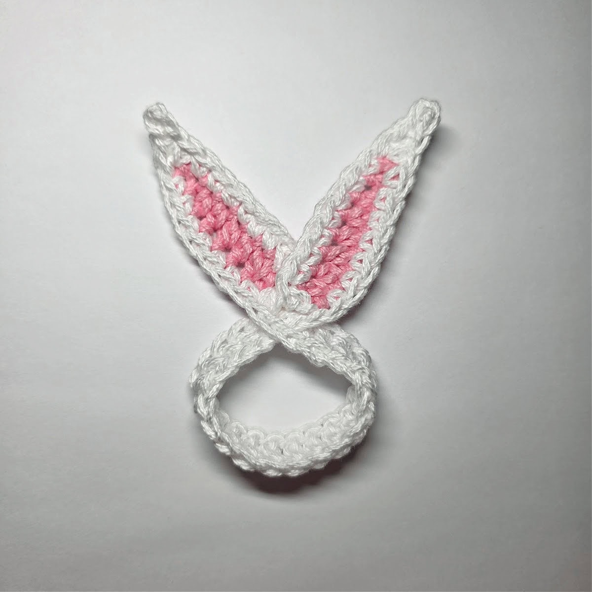 Crochet bunny ears napkin rings white with pink inner ears.