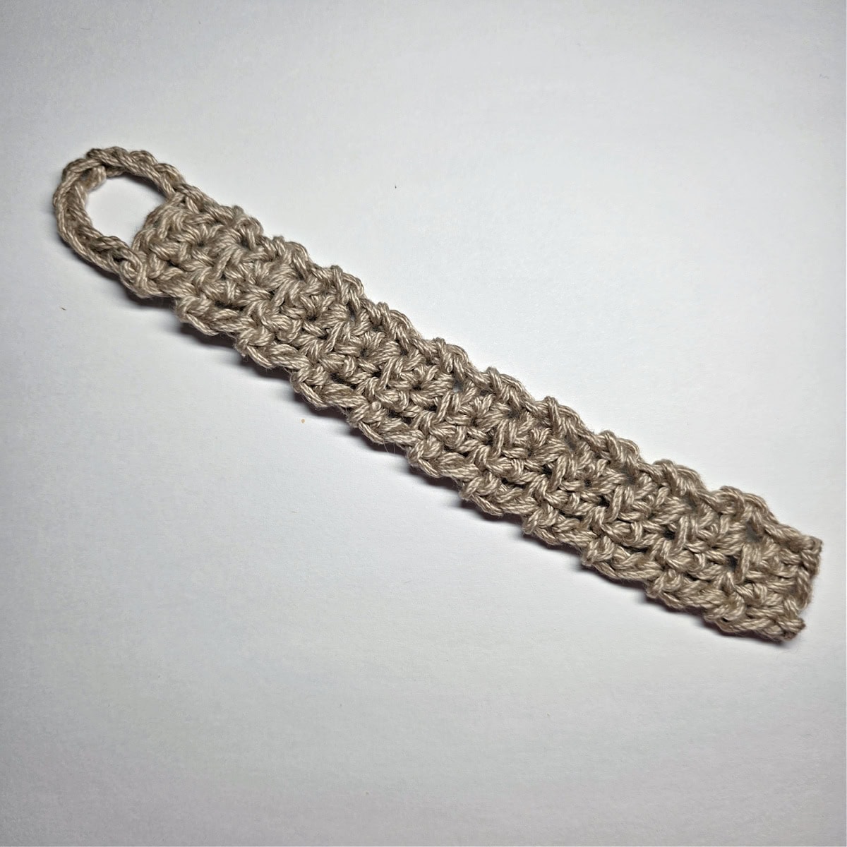 A taupe colored yarn napkin holder.