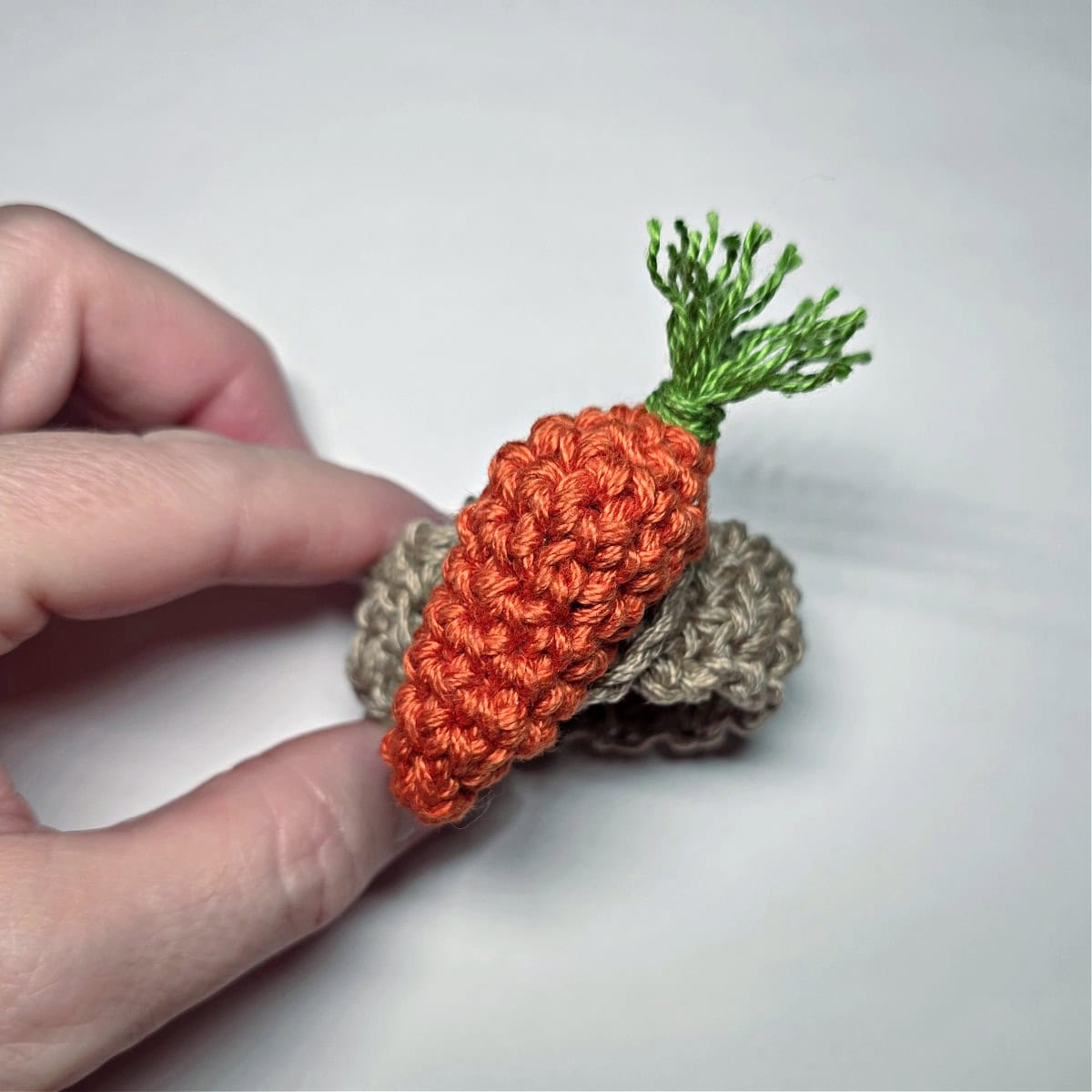 The top view of a crochet carrot napkin ring.