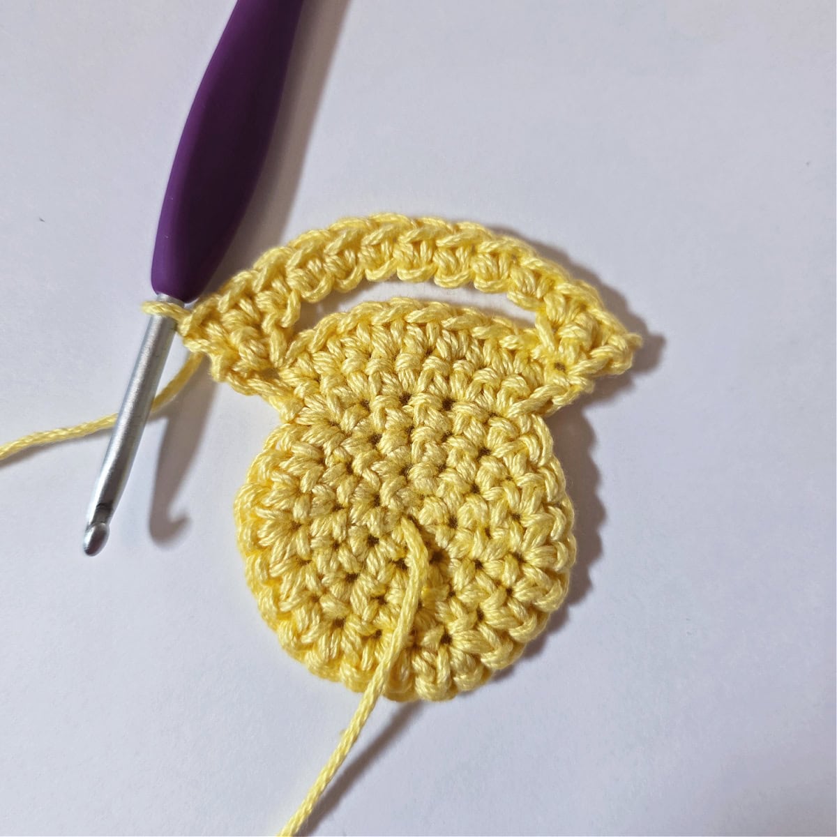 A purple crochet hook and stitches worked into the chain space made for the napkin to fit through.