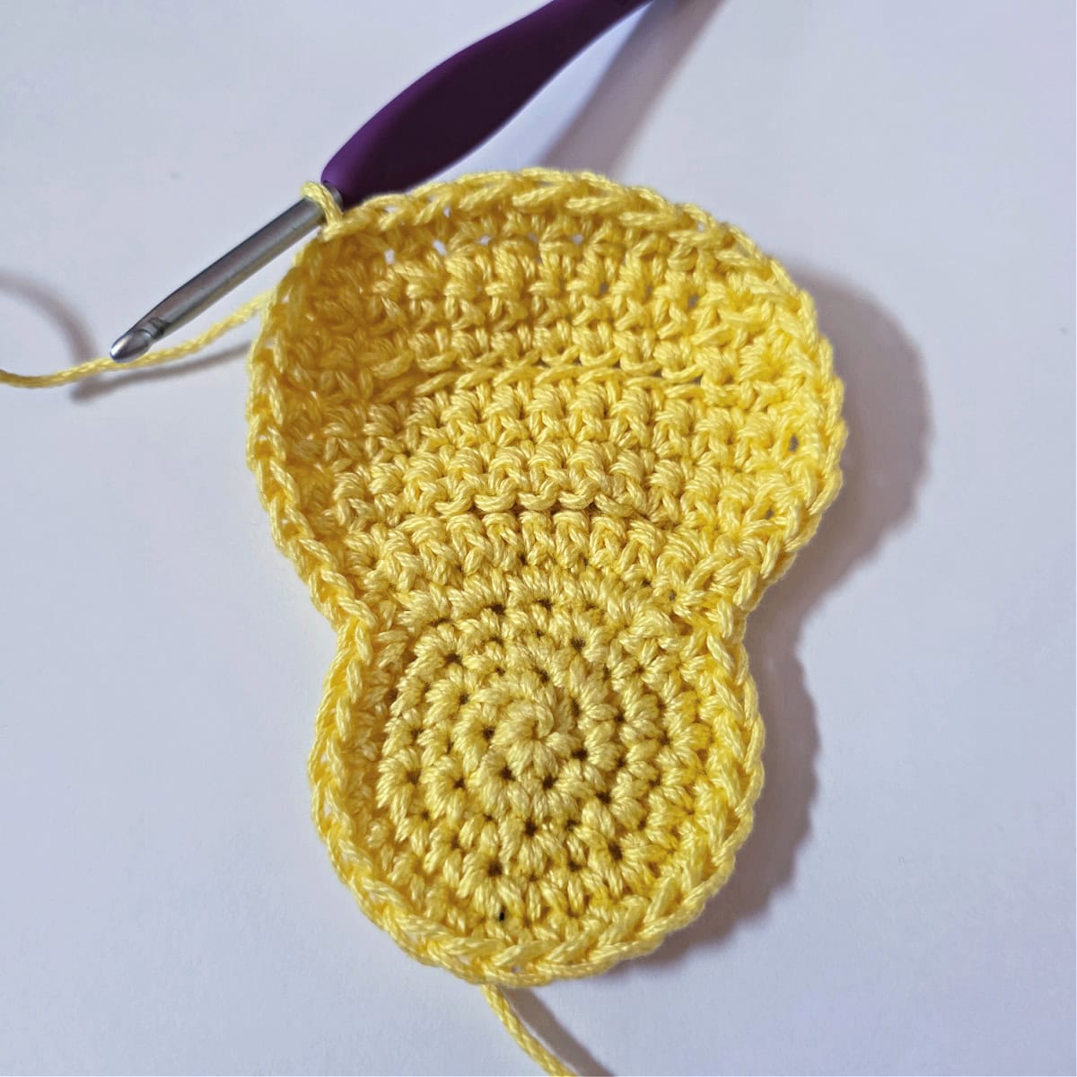 A yellow crochet easter chick napkin ring ready to add the feet.