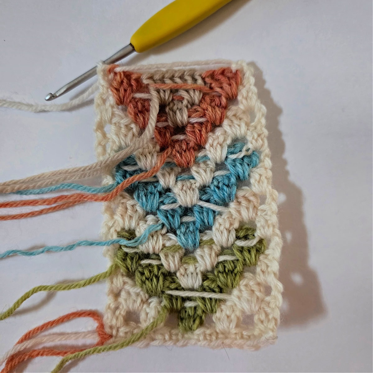 A small swatch of crochet granny stitch diamonds showing how to float yarn.