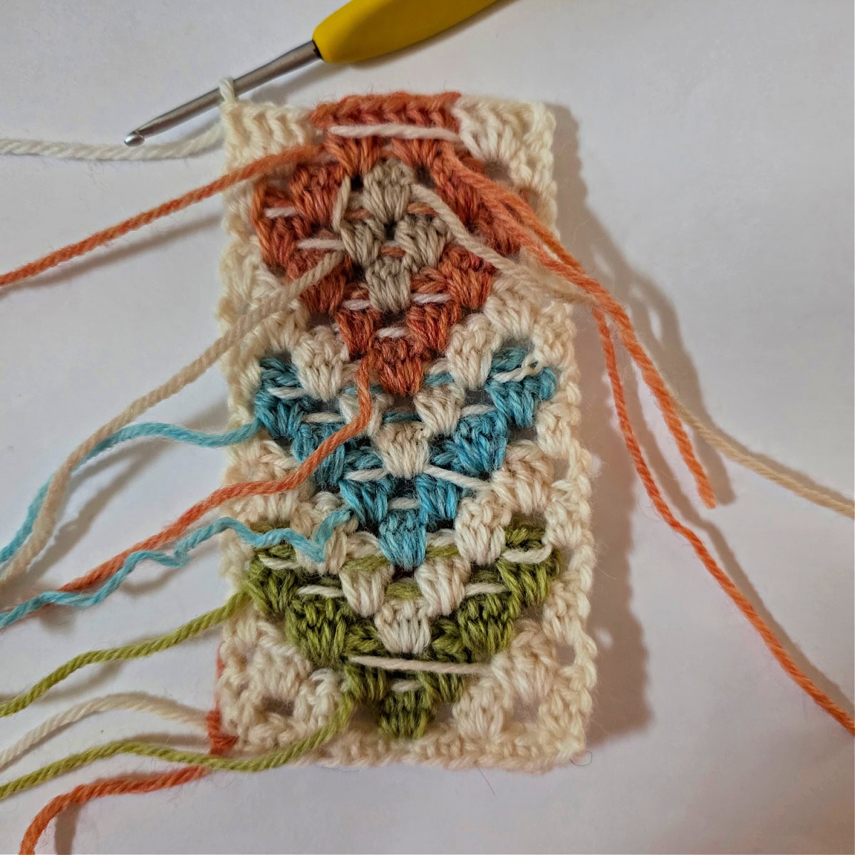 A small swatch using four colors for a boho granny stitch colorwork motif.