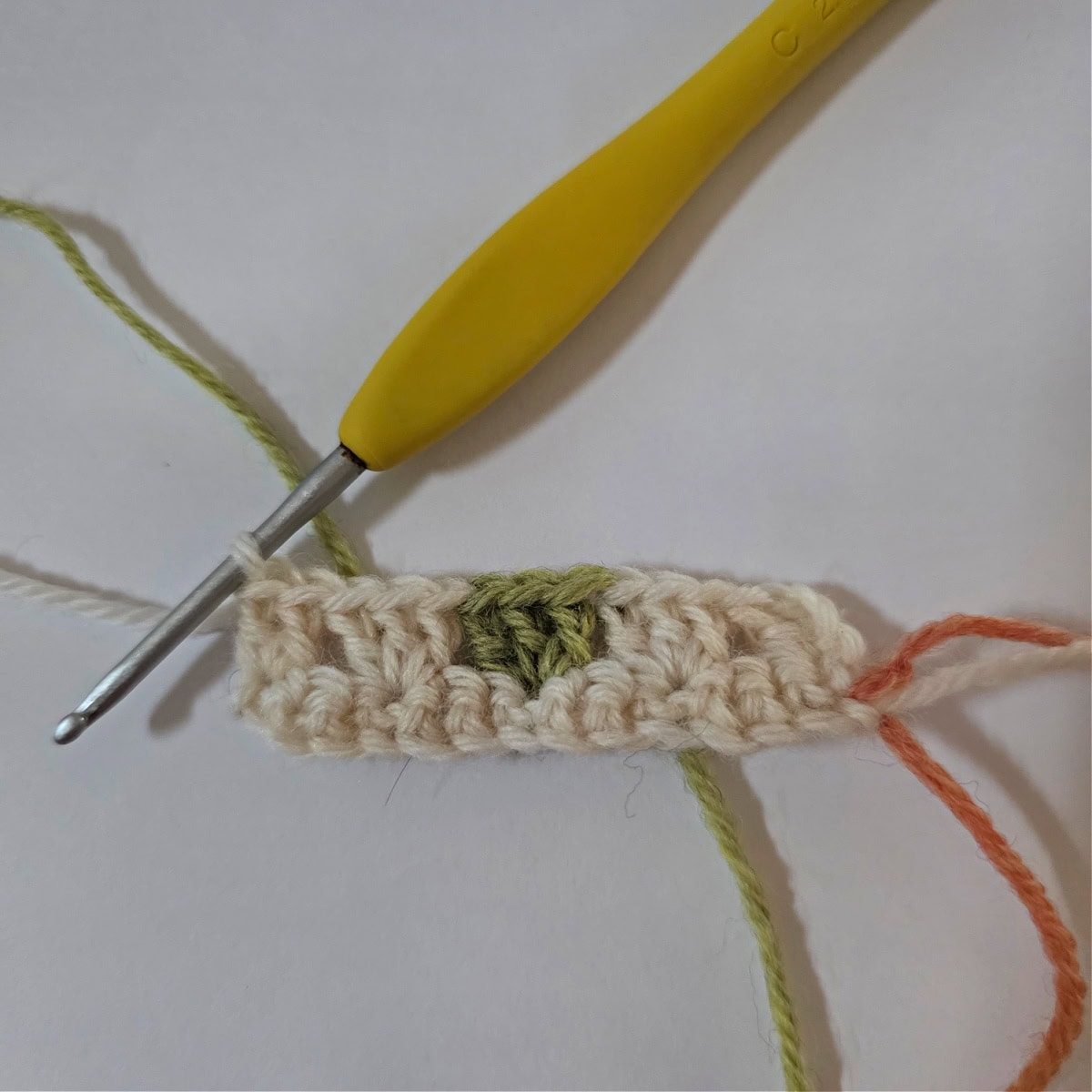 This photo shows Row 2 complete and Row A of the granny stitch colorwork color chart.